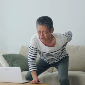 Middle aged asian man having a low back pain.