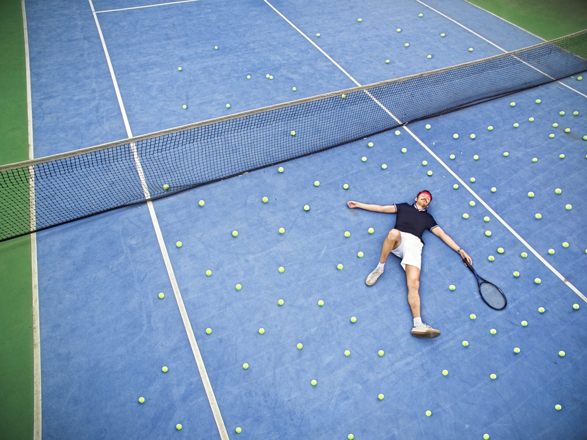 Male tennis player lying on ground